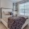 a bedroom with a large bed and a fan